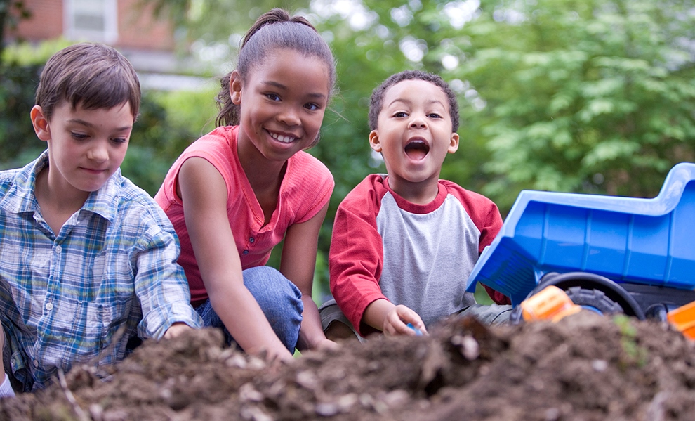 Photo of kids playing together in the dirt.