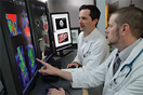 Dr. Peter Grayson (left), principal investigator of NIH’s Vasculitis Translational Research Program, reviews diagnostic images with Dr. Mark Ahlman at the NIH Clinical Center.