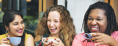 Three women holding a coffee ca